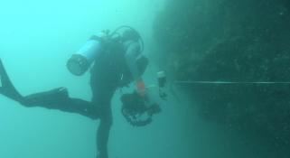 Diver under the water exploring the deep following the 50m tape
